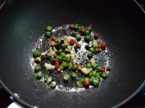 另起锅放油，放一点盐炒熟辣椒、蒜和豆豉