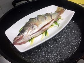 待锅里水烧开后放入蒸架子，把桂鱼放上去