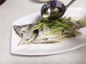 另起油锅待油微微冒烟将它淋在放有葱姜的鱼身上