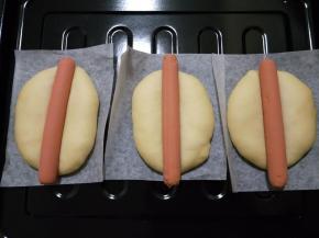 二发至两倍大小，在面团中间放一根火腿肠，轻轻压到底。