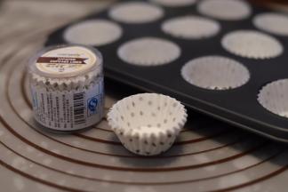 将学厨的迷你杯子纸托放入模具内，蛋糕糊装入裱花袋，挤入纸托