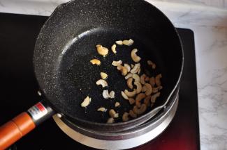 锅中放少许橄榄油，先放入腰果煸成微黄