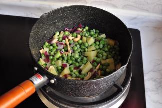 将土豆丁和豌豆丁放入锅中略炒关火。