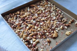 将花生和核桃放进烤箱或炒锅或饼铛，把它们烤熟，如果是用烤箱，不用预热，一般180度，十分钟到十二分钟即可。核桃要比花生熟的快些，要注意，如果花生太大，请分开烤或提前出炉。烤好的花生和核桃放凉搓去外皮，就可以使用了。我每次都多烤点，烤一次，能用三四次，节能能源还方便j省事是。