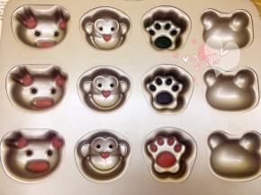 将红曲面糊挤入猪的耳朵、鼻子和猴子的鼻子。三个脚印部分分别挤入抹茶面糊、可可面糊、红曲面糊。眼睛挤入可可面糊。送入烤箱180度烤2分钟。