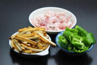 五花肉洗净切片，香干洗净切条，青椒洗净去籽，切块；