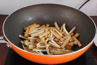 炒肉后的油留在锅中煸炒香干，六成熟，起锅；