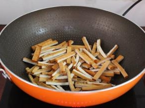 炒肉后的油留在锅中煸炒香干，六成熟，起锅；