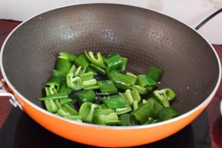 锅中放油，大火爆炒青椒六成熟；