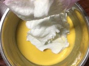把三分之一打发好的蛋白倒入蛋黄糊中，炒菜手法搅拌均匀，然后全部蛋黄糊倒回蛋白盆中