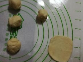 取五个小团，用擀面杖擀成小圆片。