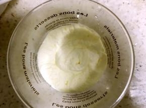 6.沿杯壁挤入一层淡奶油，左手拿杯子，右手拿裱花袋，左手缓慢旋转