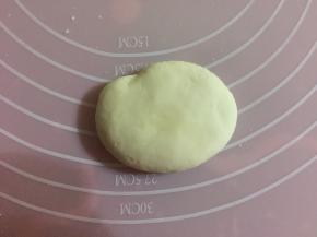 揉出气体后，取出1/5的面团，平均分成两份，揉成椭圆形，按扁。