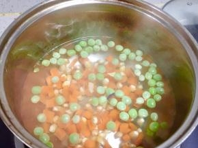 把胡萝卜丁、玉米粒、豌豆下沸水焯熟。