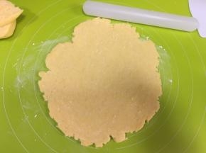 取出冷藏松弛好的面团，在揉面垫子上撒适量低粉防粘，把面团分为1:3的两份，大的面团擀到比6寸大的圆形