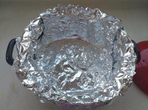 取一张锡纸放入砂锅内，另外一张锡纸十字交叉放置，一圈贴牢锅壁，包裹住锅沿、利于蒸汽挥发。