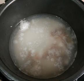 电高压锅内放适量清水，加入大米、小米，放入山药块和虾仁，启动煮粥程序。