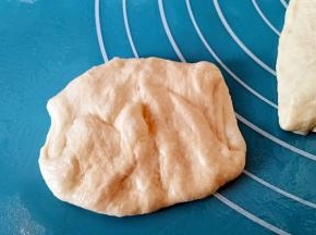 取一个剂子，按扁后在两头对折几下。