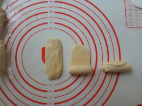 按扁，再擀成牛舌状，自下向上卷起。