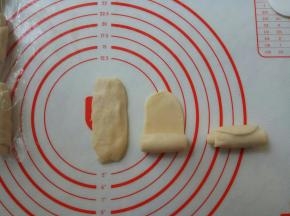 按扁，再擀成牛舌状，自下向上卷起。