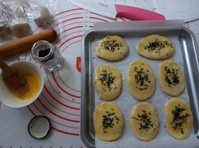 蛋黄打撒，面胚表面划三刀，刷蛋液，撒黑芝麻。