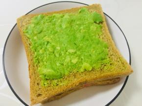 在鸡蛋上放上一片吐司，同样涂抹上牛油果泥