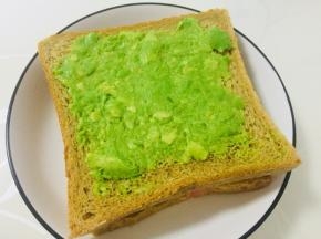在鸡蛋上放上一片吐司，同样涂抹上牛油果泥