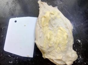 加入室温软化好的黄油继续揉至扩展阶段。