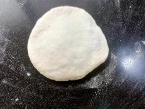 取一个面团，正面向上，用擀面杖擀开，或者用手压扁都可以。