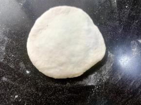取一个面团，正面向上，用擀面杖擀开，或者用手压扁都可以。