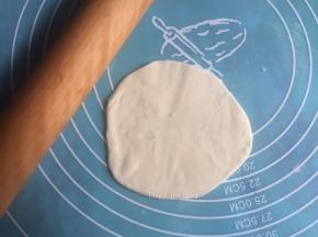 电饼铛提前预热，案板上涂抹上一层玉米油，放上一个小面团压扁后擀开
