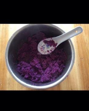 蒸熟的紫薯用勺子压成紫薯泥
