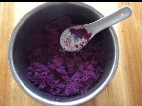 蒸熟的紫薯用勺子压成紫薯泥
