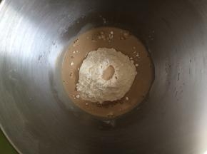 咖啡面团的制作：需要先把牛奶倒入小奶锅，开小火，牛奶温热后，加入纯咖啡粉，搅拌至咖啡粉完全化开，厨师机面桶内倒入高筋面粉，中间挖一小控倒入酵母粉，盐和糖对角线放置，倒入咖啡牛奶