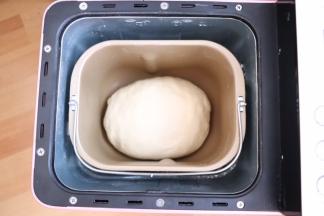 揉至扩展阶段放入提前软化的黄油；揉至可以拉出手套膜即可，盖上保鲜膜进行第一次发酵