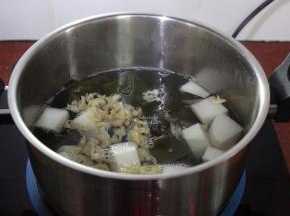 洗净锅，倒入适量的清水，煮沸，放入白萝卜、海带结、花蛤肉、生姜；