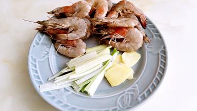 大虾去掉虾肠，去掉虾须，虾背割刀，葱切丝，姜切片。