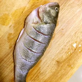 新鲜鲈鱼收拾干净，横切几刀，双面抹适量料酒，盐入味