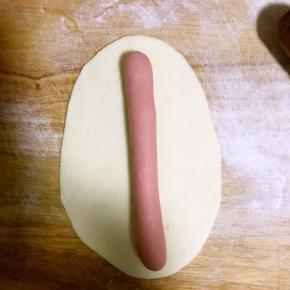 取其中一个擀成椭圆形长片，取另一色面团撮成圆条，如图所示放到面皮上