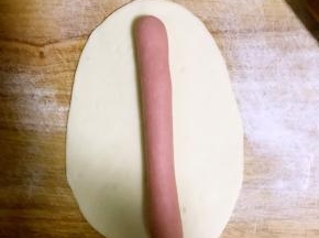 取其中一个擀成椭圆形长片，取另一色面团撮成圆条，如图所示放到面皮上