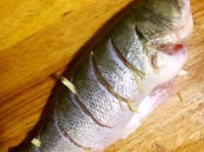 将姜丝塞入鱼肚，鱼嘴及鱼身开口处腌制十五分钟