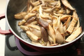 下入香菇和平菇炒软。