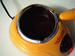 将巧克力碎块放入巧克力炉，用二档融化巧克力。