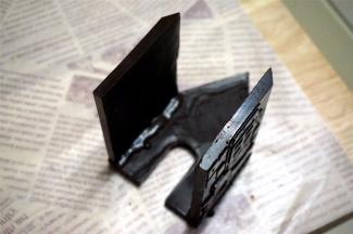 将正门那片零件放平，背部朝上。然后将带窗户的两面墙体其中一边涂上巧克力浆，然后粘到正门面上，如图。