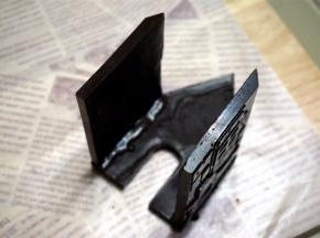 将正门那片零件放平，背部朝上。然后将带窗户的两面墙体其中一边涂上巧克力浆，然后粘到正门面上，如图。