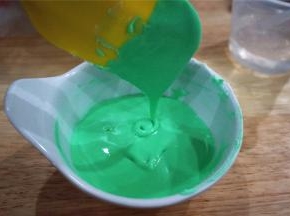 取两大勺浓稠糖霜，加入几滴绿色素，然后分次少量加入凉开水，调成可以流动的糖霜，糖霜的状态为滴落的纹路能在几秒钟后消失即可。