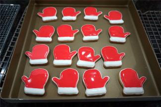 取适量的白色浓稠糖霜，加入凉开水，调成白色的稀糖霜，给手套的毛绒部位填色，如图。