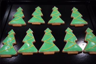 取少许白色的浓糖霜，加入几滴黄色素，调成黄色浓糖霜，在圣诞树身上画上Z形。