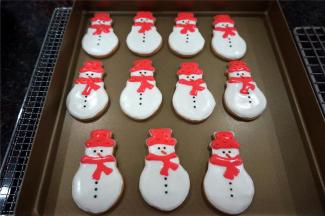 用少许黑色糖珠，给雪人点睛，以及装上纽扣。用橙色糖珠给雪人的帽子装饰，用橙色针糖点缀雪人的鼻子嘴巴，完成。