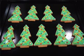 取少许白色的浓糖霜，加入少许蓝色素，调成蓝色的浓糖霜。分别用蓝色，红色，黄色，白色浓糖霜在圣诞树身上画上彩色点点，圣诞树糖霜饼干完成，放置通风处晾干即可。